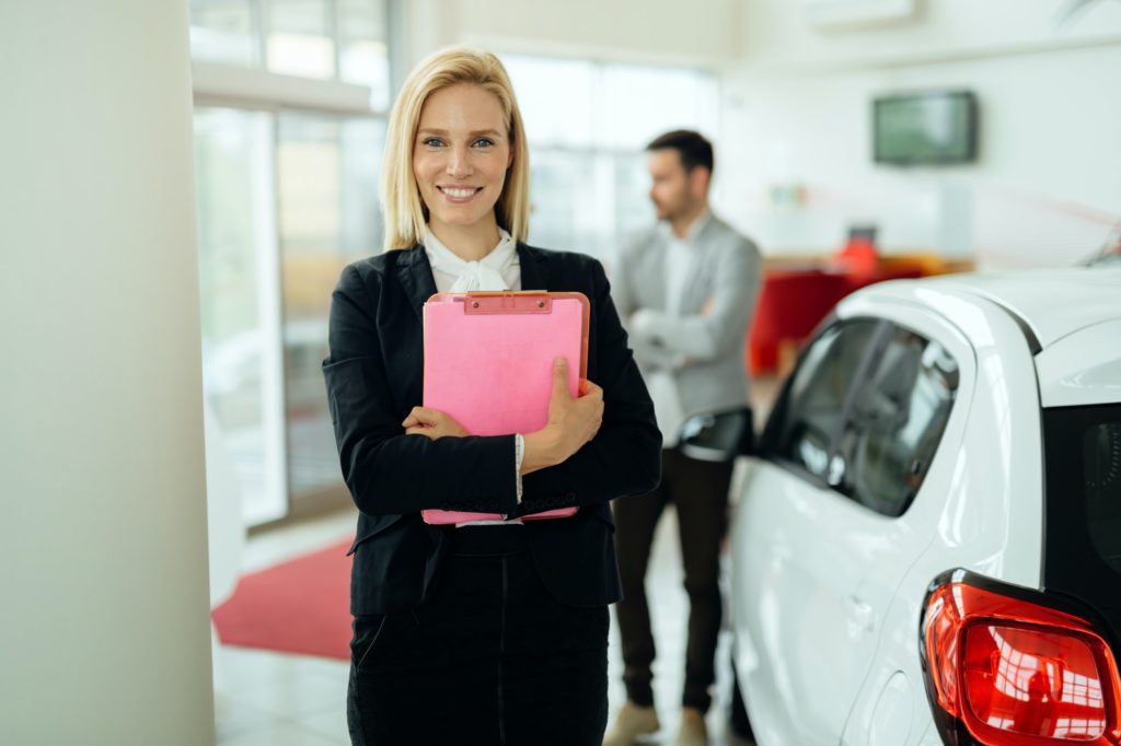 Salesperson selling cars at dealership